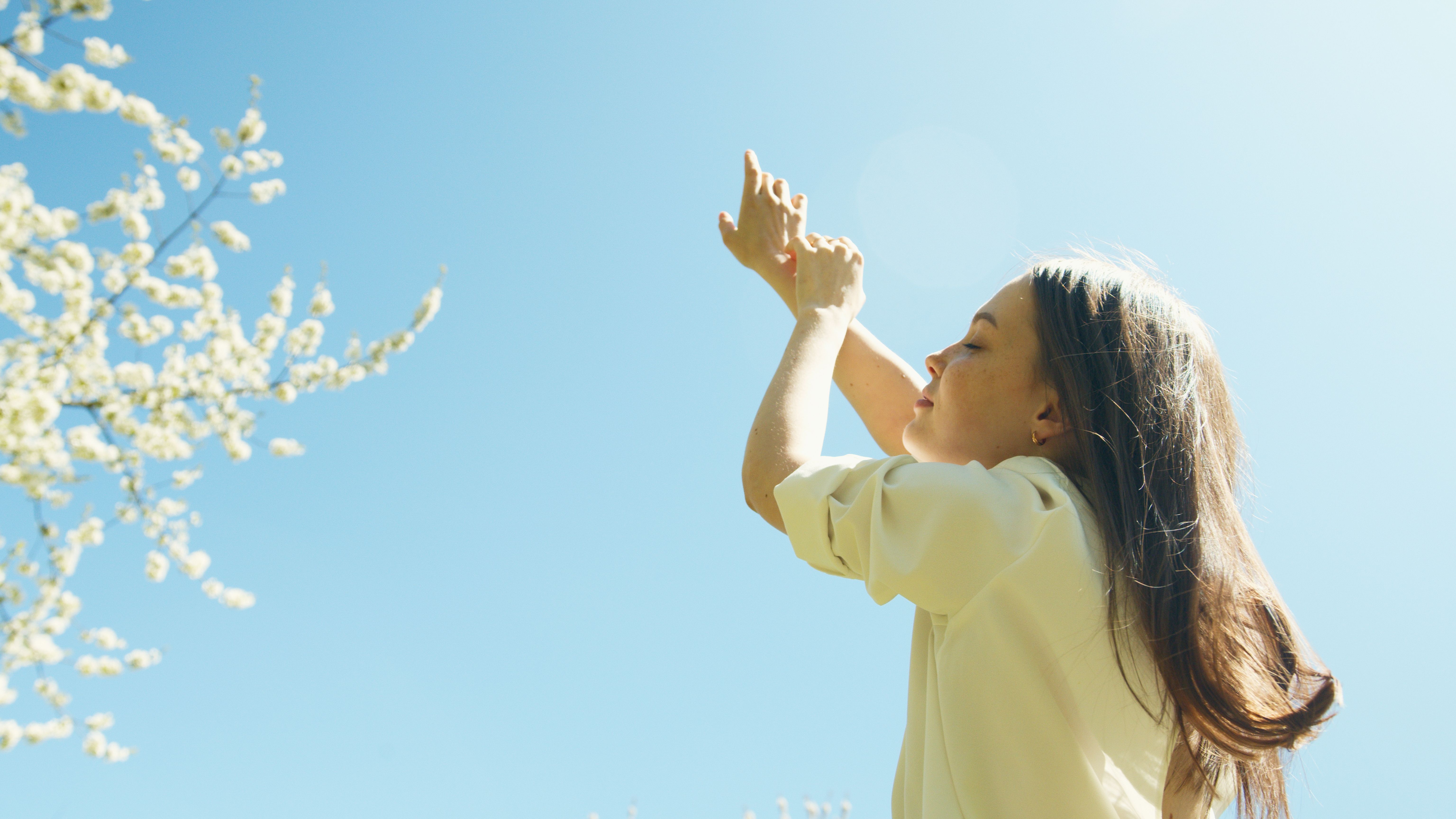Woman with arms raised feeling free, wellness lifestyle photo